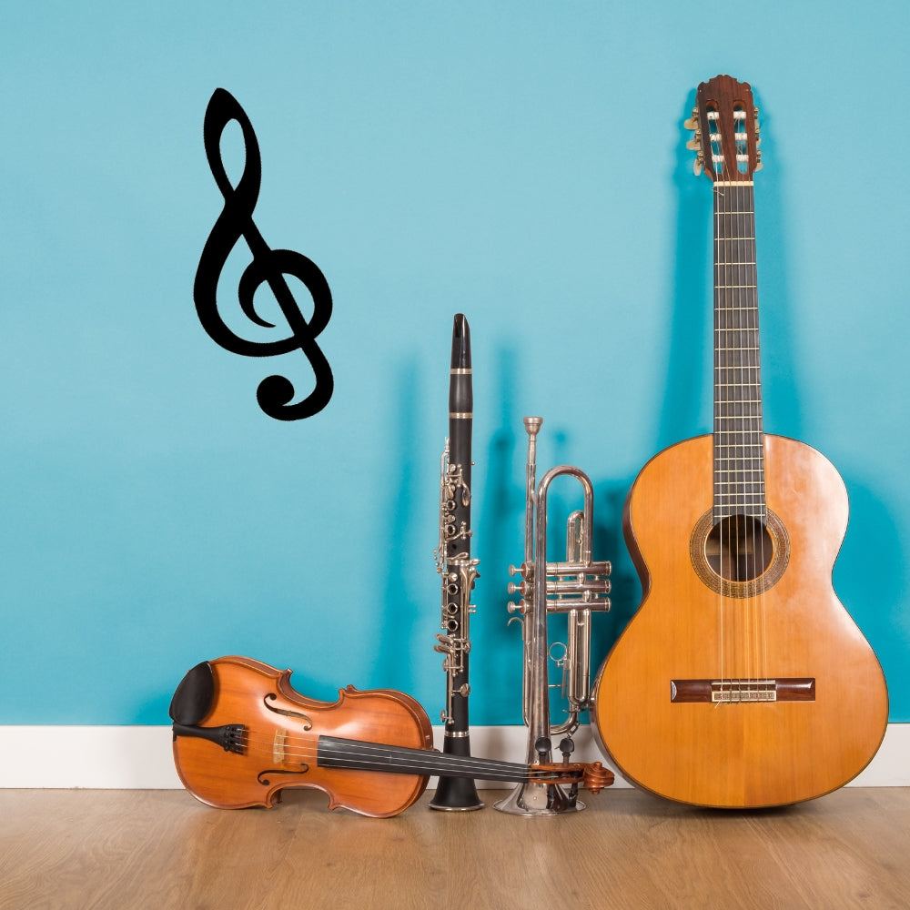 Precut glass shape of a treble clef with instruments.