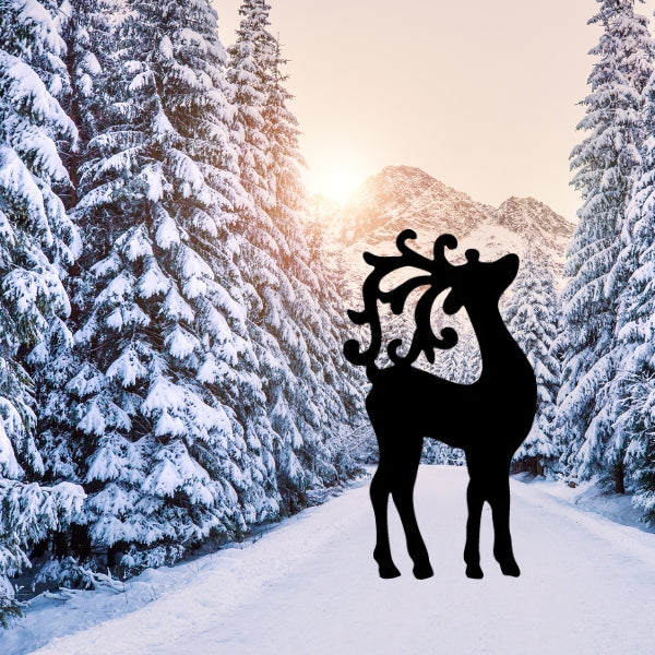 Black Bullseye COE 90 glass silhouette of a reindeer precut standing on a snowy path with glowing bokeh lights and snow-covered trees in the background, evoking a magical winter scene.